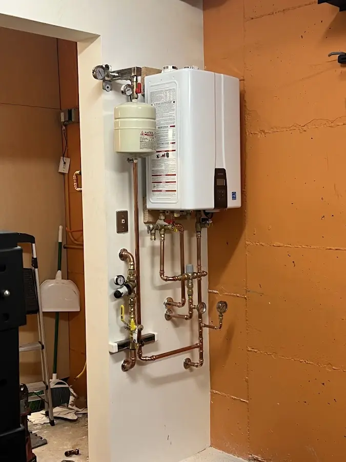 Plumbing technician inspecting water heater connections in Tanque Verde
